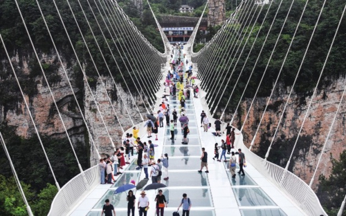 湖南張家界:旅游業持續“升溫”,景區迎客流高峰
暑期以來,湖南省張家界市各大景區推出“避暑游”“研學游”“親子游”等多種定制化旅游產品,進一步豐富旅游資源,激發夏日旅游市場活力。游客們登高望遠、林間漫步、乘船游湖,暢享盛夏清涼,感受秀美風光。圖為游客在張家界大峽谷景區玻璃橋游覽。新華社